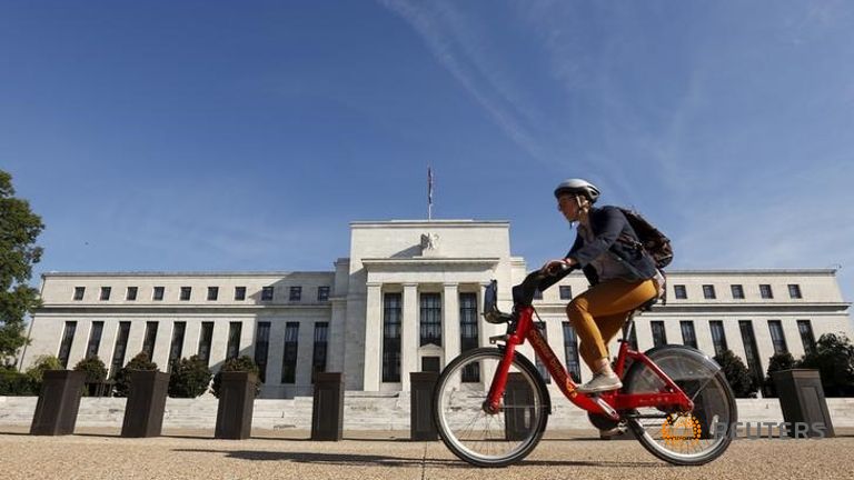 A cyclist passes the Federal Reserve headquarters in Washingt