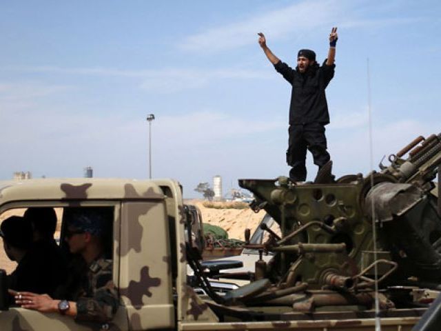 A fighter from Misrata shouts to his comrades as they move to fight Islamic State militants near Sirte