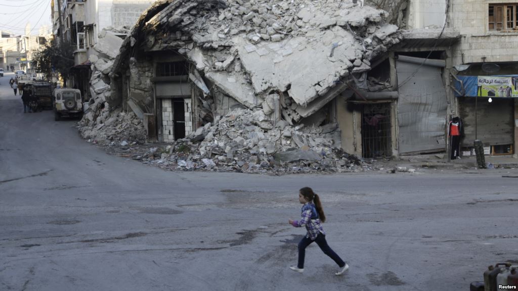 A girl runs past damaged buildings in the rebel-controlled area of Maaret al Numan town in Idlib province Syria Dec. 21 2015