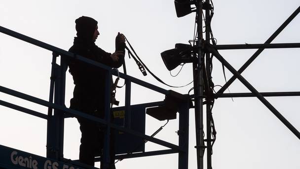 A worker dismantles a part of the light and fireworks installation in Brussels