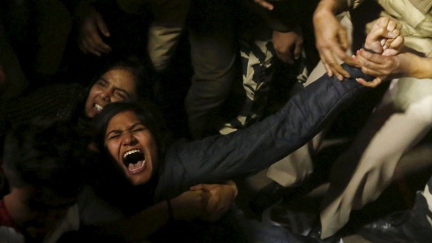 A demonstrator is detained by police during a protest against the release of a juvenile rape convict