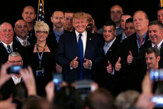 Donald Trump stands with supporters after receiving an endorsement from a New Hampshire police union