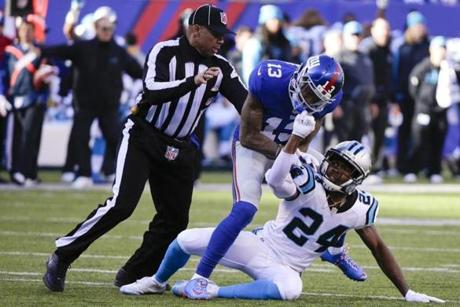 A referee left separates New York Giants wide receiver Odell Beckham and Carolina Panthers&apos Josh Norman during the first half of an NFL football game Sunday Dec. 20 2015 in East Rutherford N.J