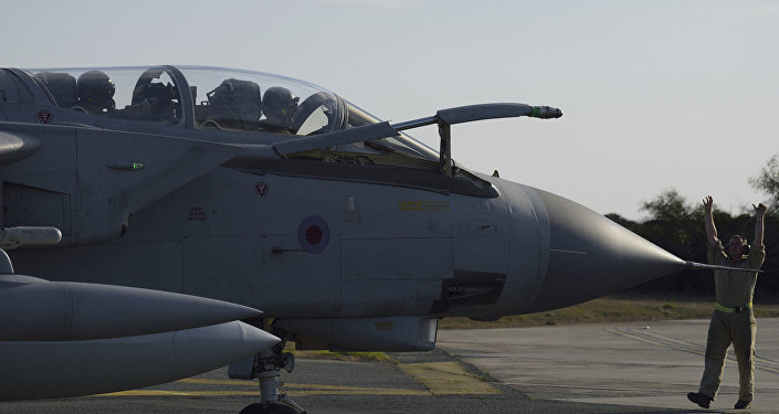 A ground crewman directs a Royal Air Force Tornado along the tarmac of a British air base in Akrotiri Cyprus after returning from an airstrike against Islamic State group targets in Syria Thursday Dec. 3 2015