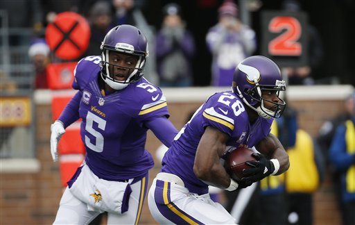 El running back de los Vikings de Minnesota Adrian Peterson recibe el balón de manos del quarterback Teddy Bridgewater durante la primera mitad del juego ante los Bears de Chicago el domingo 20 de diciembre de 2015 en Minneapolis