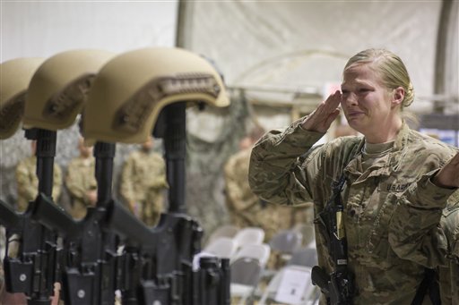 A U.S. service member salutes her fallen comrades during a memorial ceremony for six Airmen killed in a suicide attack at Bagram Air Field Afghanistan on Wednesday Dec. 23 2015. The deadliest attack in Afghanistan since 2013 killed six U.S. troops