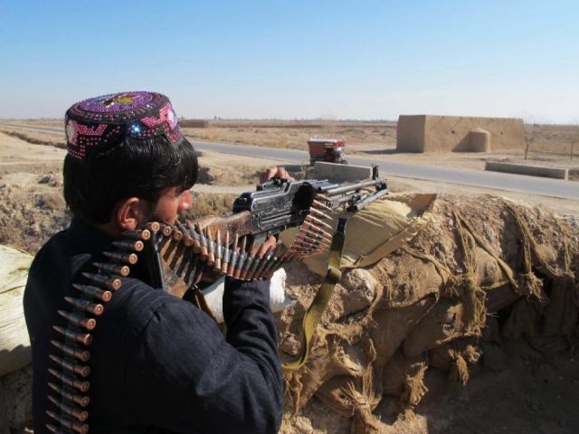 Afghan police keep watch during an ongoing battle with Taliban militants in the Marjah district of Helmand Province