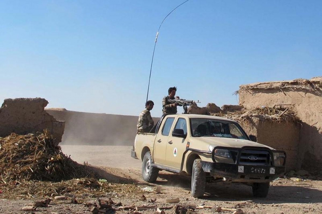 An Afghan National Army soldiers drive at an outpost in Helmand province