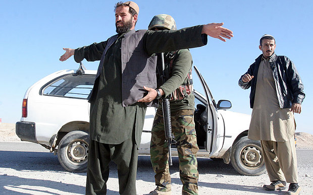 An Afghan National Army soldier searches a passenger at a checkpoint on the way to the Sangin district of Helmand province Afghanistan Wednesday Dec. 23 2015