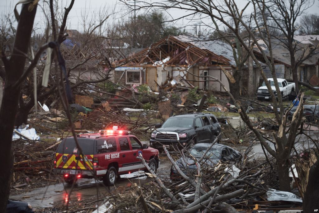 An emergency vehicle drives through a neighborhood in Rowlett Texas Sunday Dec. 27 2015