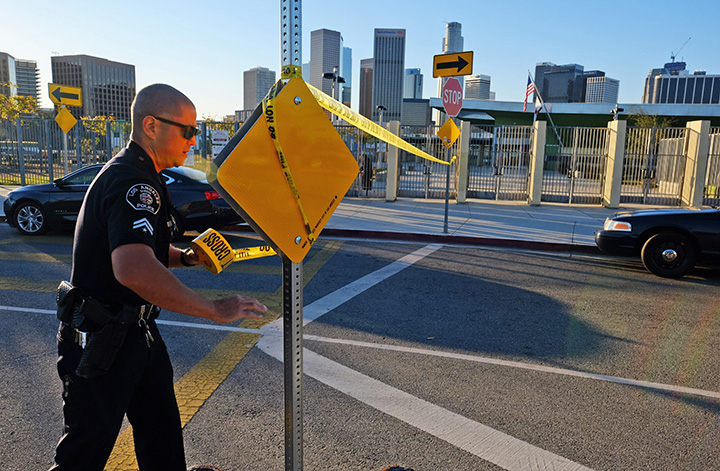 A police officer puts up yellow tape outside of Edward Roybal High School in Los Angeles on Tuesday morning Dec. 15 2015