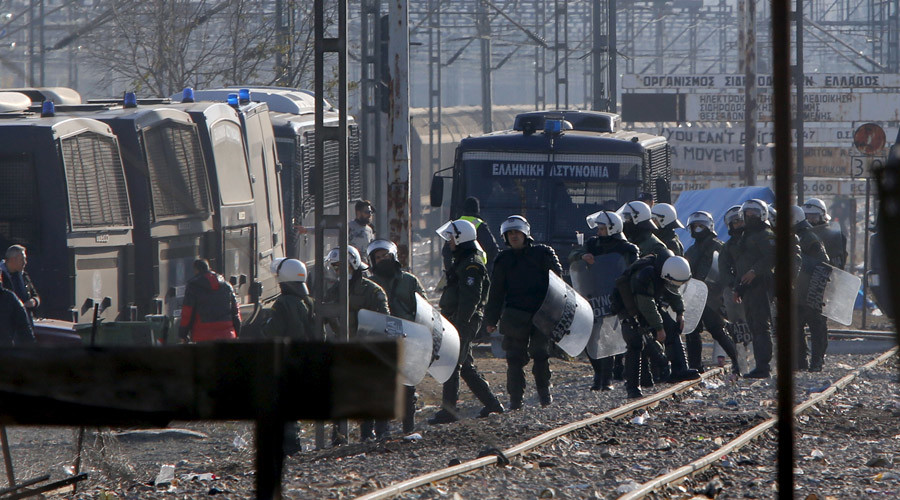 Greek police officers guard the perimeter where hundreds of migrants who were stranded on the Greek Macedonian border and blocking rail traffic are gathered in tents after a police operation near the village of Idomeni Greece