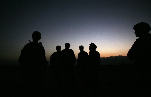 U.S. Army soldiers stand with Afghan policemen before a joint patrol of Qalanderkhail outside of Bagram Air Field in Afghanistan. An Afghan official says that a suicide bomber has killed three foreign troo