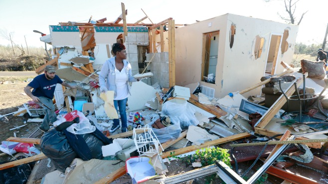 Trista Boga center helps salvage what she can from a freinds home along Highway 178 in Holly Springs Mississippi on Thursday December 24 2015