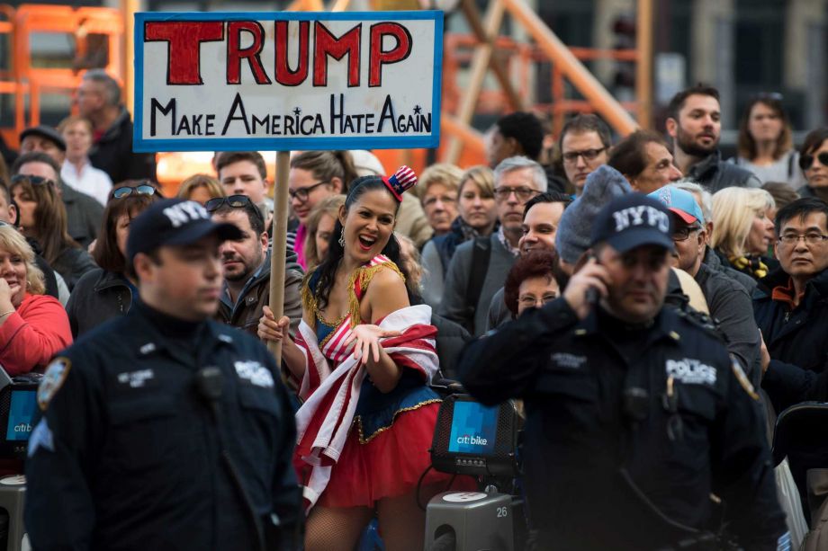 Protesters on Friday rally outside the Plaza Hotel in New York where Donald Trump spoke at a luncheon. Though Trump mocks his opponents as low energy his own campaign travel schedule is relatively sleepy