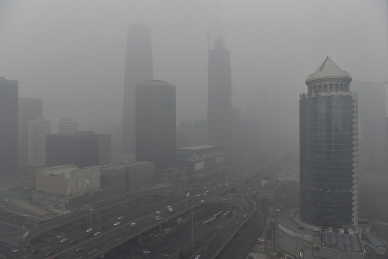 Vehicles travel on the Guomao bridge as the Central Business District area is seen amid heavy smog after the city issued its first ever'red alert for air pollution in Beijing China