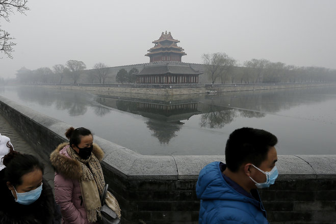 People wearing masks walk past the Turret of the Forbidden City on a heavily polluted day in Beijing Tuesday Dec. 8 2015. Beijing's red alerts for smog are as much about duration as they are about severity of pollution forecasts. The forecasting model