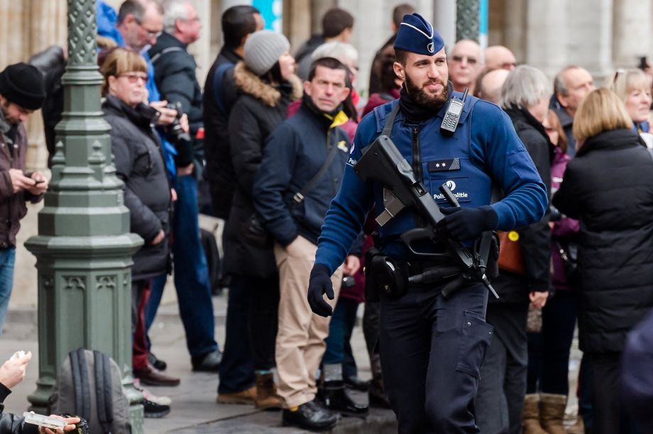 A police officer patrols the Grand Place in central Brussels. Investigators believe 2 detained suspects were plotting to attack this central square the city’s largest tourist attraction