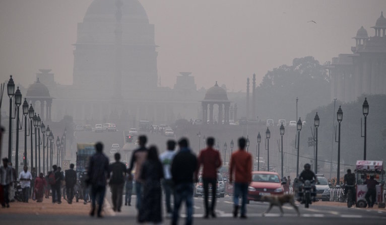 Indian pedestrians walk near smog enveloped government offices on Rajpath in New Delhi on Tuesday. India's capital has the world's most polluted air with six times what is considered safe according to the World Health Organization