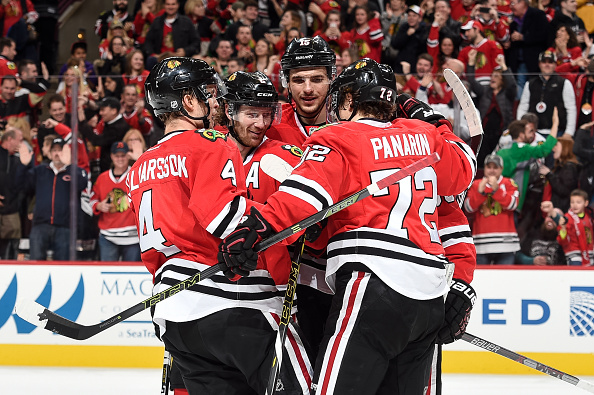 Niklas Hjalmarsson #4 Duncan Keith #2 Artem Anisimov #15 and Artemi Panarin #72 of the Chicago Blackhawks celebrate after Panarin scored an empty net goal in the third period of the NHL game against the Winnipeg Jets at the United Center on December 6