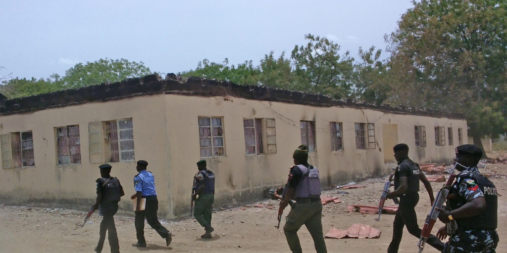 April 21. 2014 security walk past a burnt out government secondary school in Chibok where gunmen abducted more than 200 students Chibok Nigeria