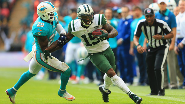 Brandon Marshall #15 of the New York Jets holds off Reshad Jones #20 of the Miami Dolphins during the game at Wembley Stadium