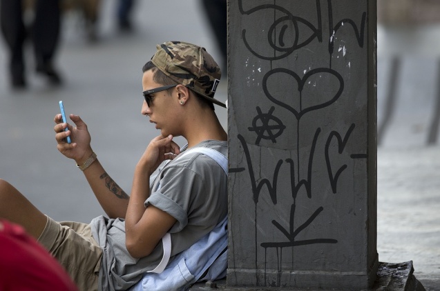 A youth checks his cell phone in Sao Paulo Brazil Thursday. Brazilians awoke to a day without What App Thursday after a judge ordered the popular messaging app blocked throughout the country for 48 hours. In a statement Sao Paulo's criminal court system