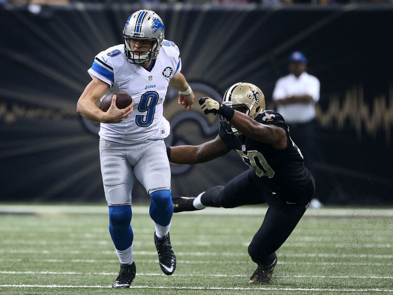 Matthew Stafford avoids a tackle by Stephone Anthony