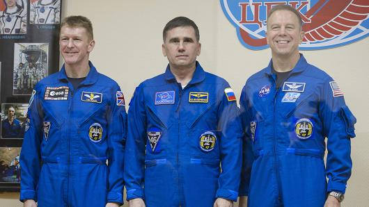 Expedition 46 Flight Engineer Tim Peake of the European Space Agency, Soyuz Commander Yuri Malenchenko of the Russian Federal Space Agency and Flight Engineer Tim Kopra of NASA pose for at the end of a press conference