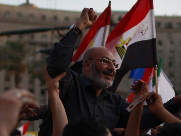 Protesters hold cleric Safwat Hijazi during a demonstration at Tahrir square in Cairo