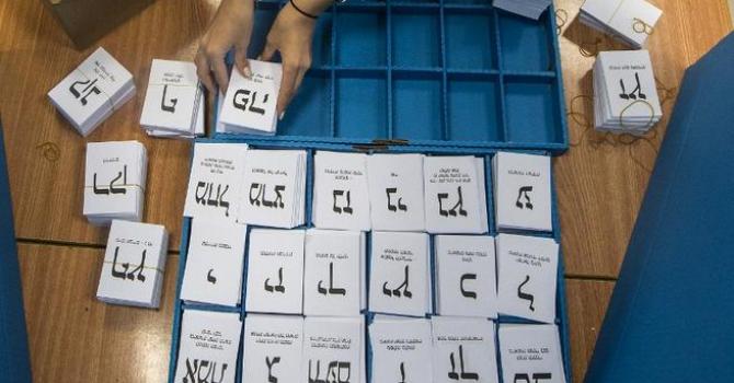 An Israeli polling station worker arranges ballots during Israel's general elections in Haifa