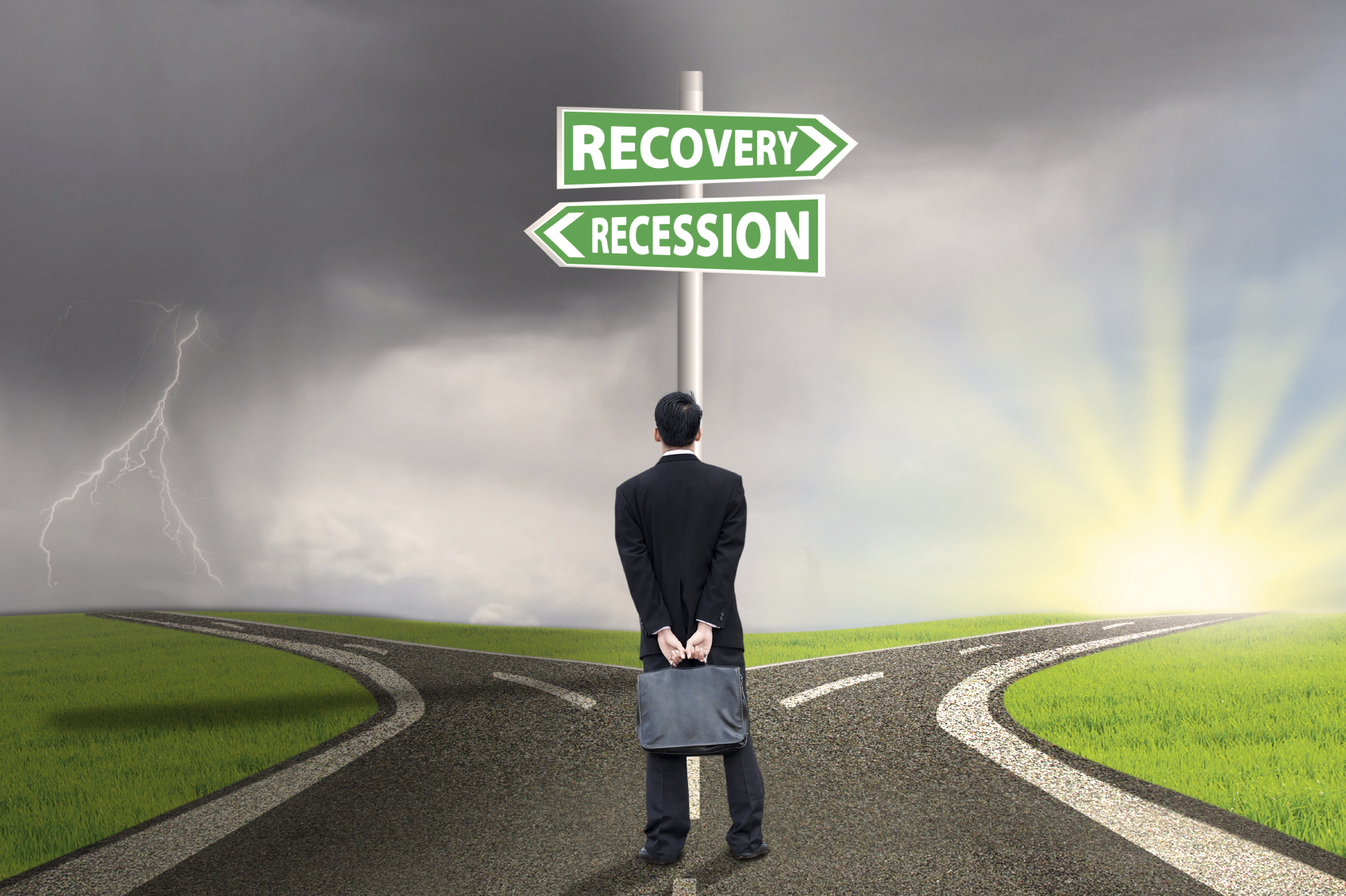 Businessman standing on the road while looking at the road sign guide to recession and recovery finance