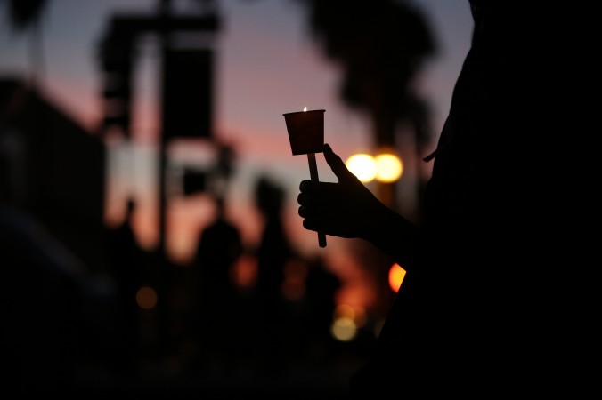 Cathleen Garcia holds a candle during a vigil to honor shooting victims on Monday Dec. 7 2015 in San Bernardino Calif. The husband and wife who opened fire on a social services center last week had been radicalized'for quite some time and had taken