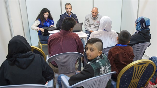 A young Syrian refugee looks back as his family are being interviewed by authorities in hope of being approved for passage to Canada at a refugee processing centre in Amman Jordan on Sunday Nov. 29 2015