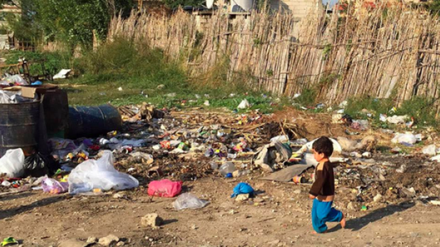 A boy walks in a refugee camp in Lebanon yesterday. Syrian refugees arriving in Canada will come from camps in Lebanon Turkey and Jordan. Families with young children will be among the refugees allowed