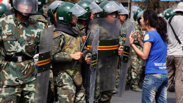 An Uighur woman protests before a group of paramilitary police in Urumqi capital of northwest China's Xinjiang Uygur Autonomous Region July 7, 2009