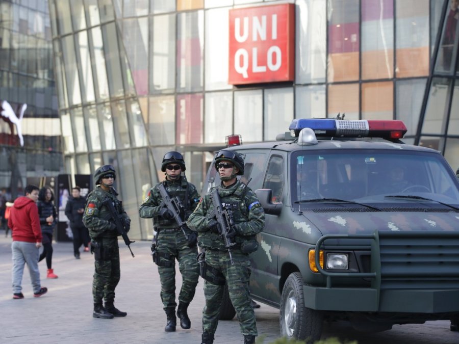 Armed policemen of the Snow Leopard Commando Unit stand guard near a police van at the Sanlitun area a fashionable location for shopping and dining in Beijing China