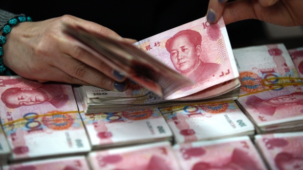 A clerk counts Chinese currency notes at a bank branch in Huaibei in Anhui province. Inclusion of the yuan in the IMF's reserve basket of currencies would be a big political win for China