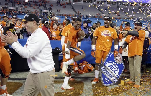 Clemson quarterback Deshaun Watson holds a football as coach Dabo Swinney celebrates after Clemson defeated North Carolina 45-37 in the Atlantic Coast Conference championship NCAA college football game in Charlotte N.C. early Sunday Dec. 6 2015. (AP P