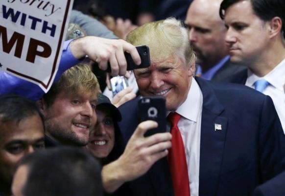 Republican presidential candidate Donald Trump poses with supporters