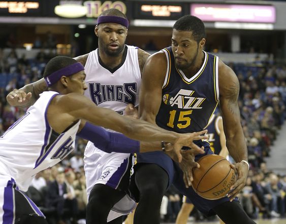 Rajon Rondo left tries to steal the ball from Utah Jazz forward Derrick Favors right as Kings forward De Marcus Cousins center looks on during the first quarter of an NBA basketball game in Sacramento Calif. Tuesday De