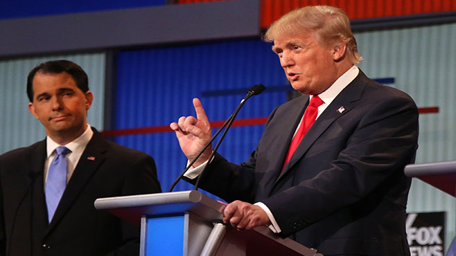 Republican presidential candidate Donald Trump speaks as Wisconsin Gov. Scott Walker listens during the first Republican presidential debate at the Quicken Loans Arena Thursday Aug. 6 2015 in Cleveland