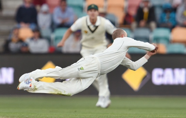 Australian spinner Nathan Lyon dives to take a catch to dismiss West Indies batsman Marlon Samuels on the second day of their first Test match in Hobart