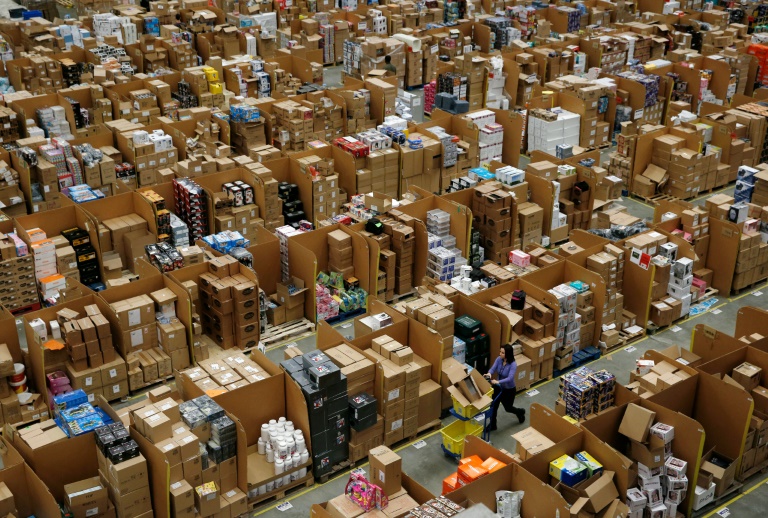 AFP  File  Adrian Dennis Workers walk along aisles of goods stored inside