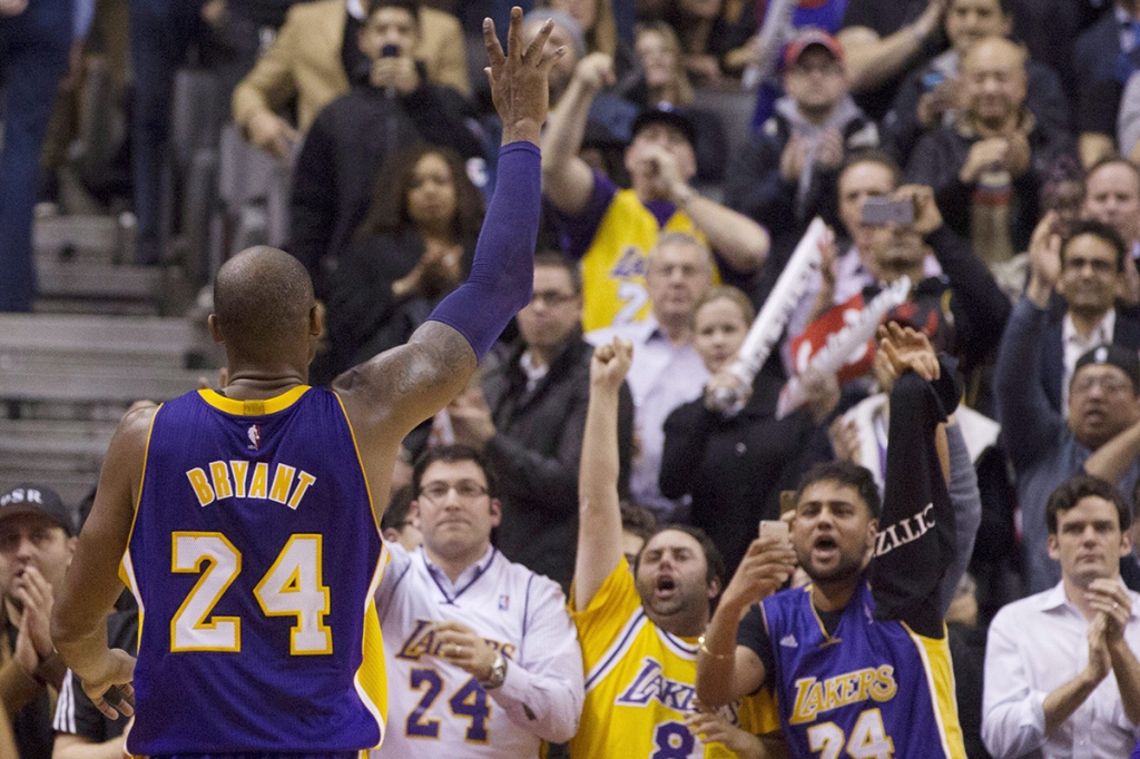 Los Angeles Lakers's Kobe Bryant gestures to the crowd as he returns to the bench in the final seconds of the second half