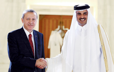 DOHA Turkish President Recep Tayyip Erdogan and Qatari Emir Tamim bin Hamad Al Thani shake hands during a ceremony yesterday.- AP