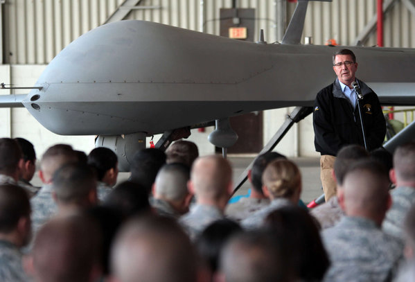 Defense Secretary Ash Carter, on a Mideast tour addresses American troops as he stands in front of a drone at Incirlik Air Base near Adana Turkey. Associated Press