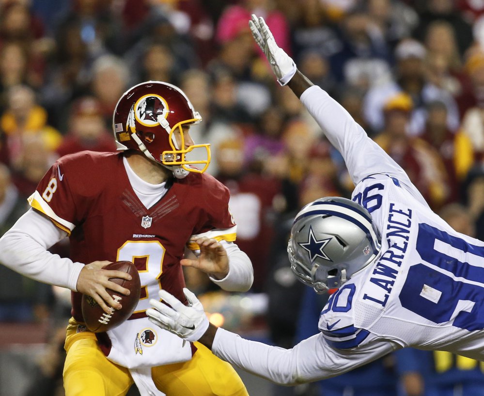 Cowboys defensive end Demarcus Lawrence leaps at Washington quarterback Kirk Cousins for a sack during the first half of their game Monday in Landover Maryland