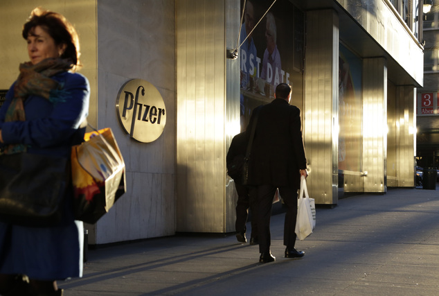 People pass Pfizer's world headquarters Monday Nov. 23 2015 in New York. Pfizer and Allergan will join in a $160 billion deal to create the world's large