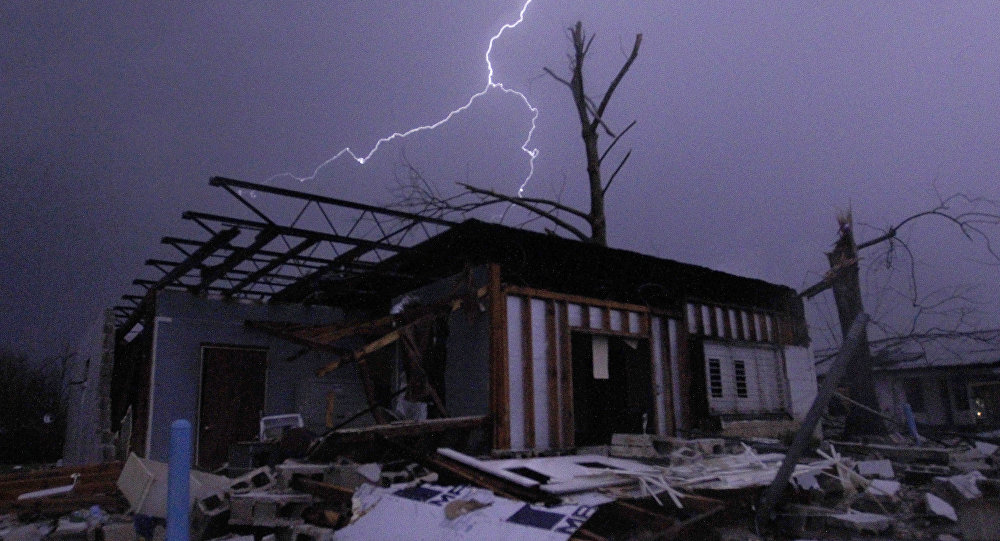 Lightning illuminates a house after a tornado touched down in Jefferson County Ala. damaging several houses Friday Dec. 25 2015 in Birmingham Ala. A Christmastime wave of severe weather continued Friday